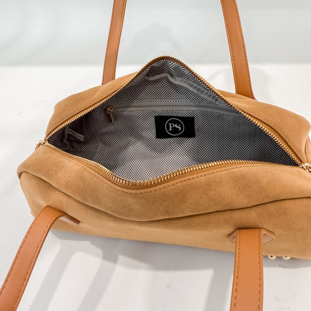 Camel suede barrel bag interior with chevron lining and small patch logo