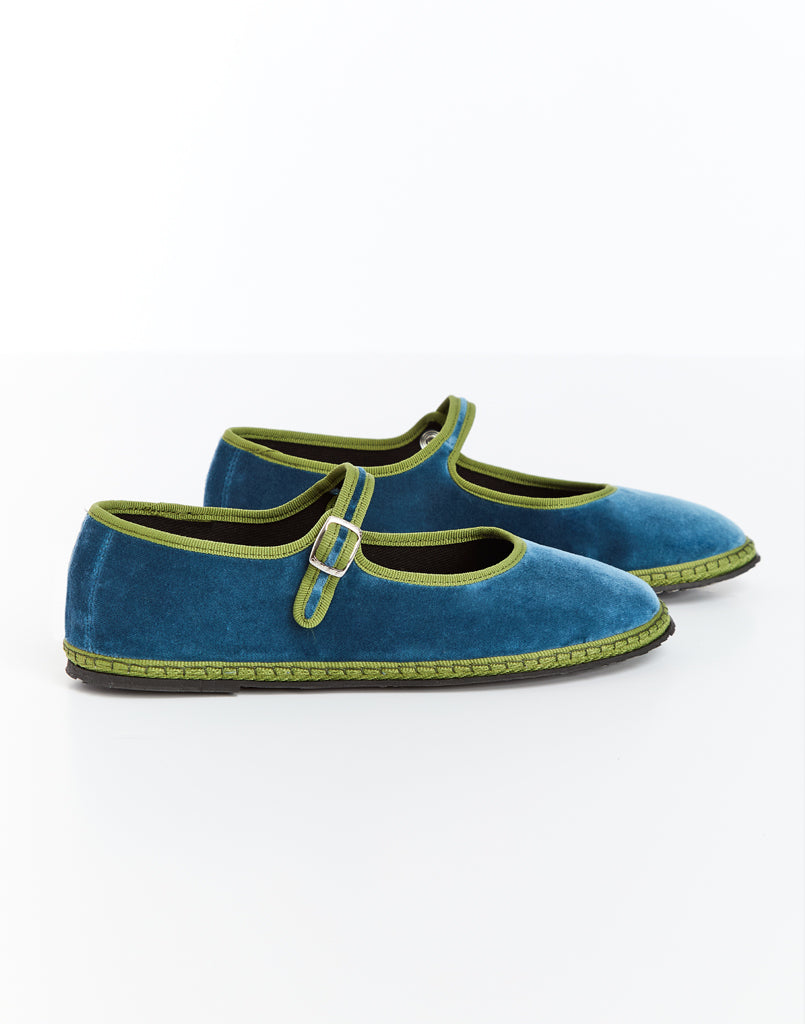 Blue Mary Jane shoes with green trim and buckled strap, angled side view