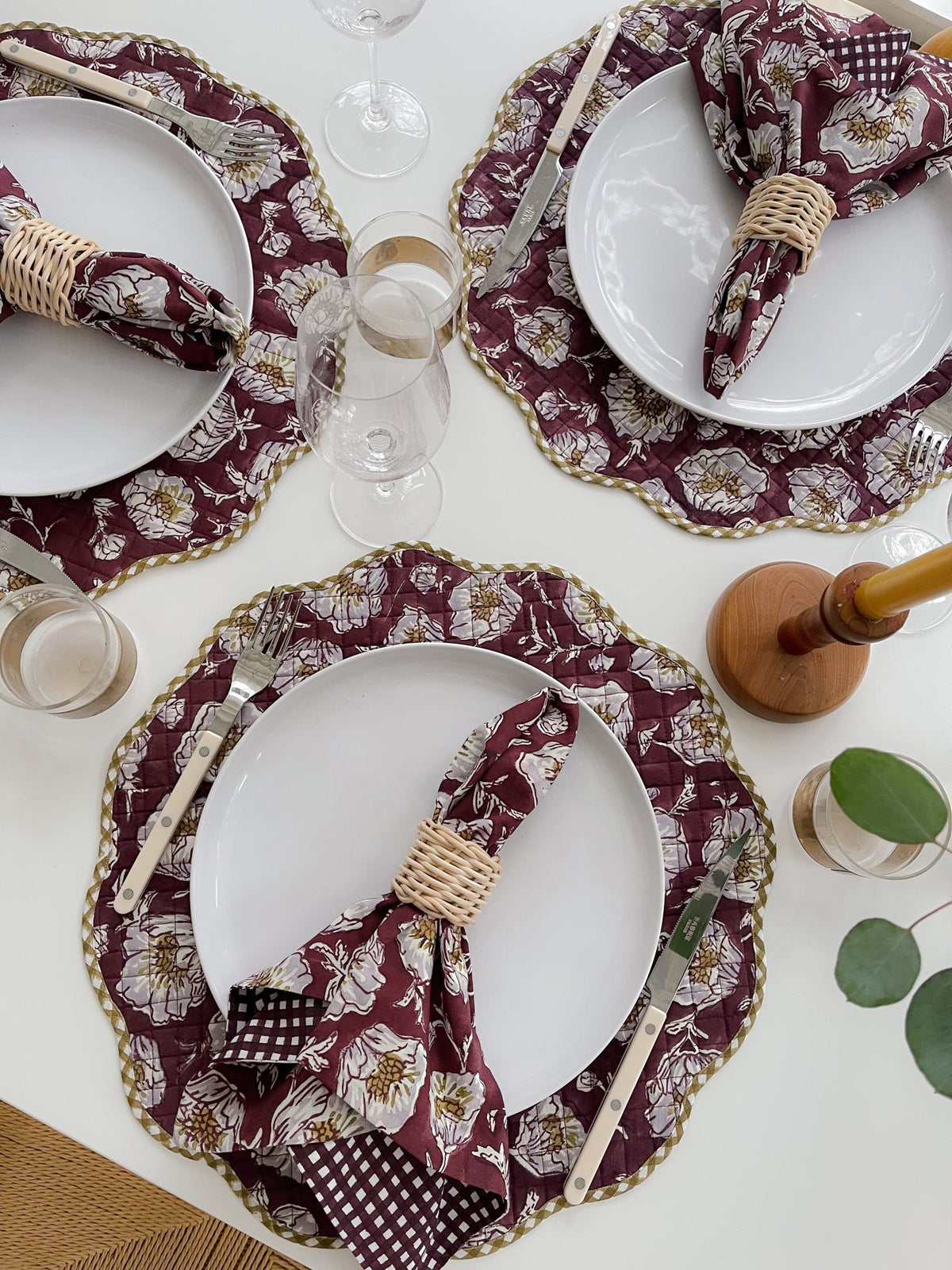 Wine floral placemats with scalloped edges set at a table