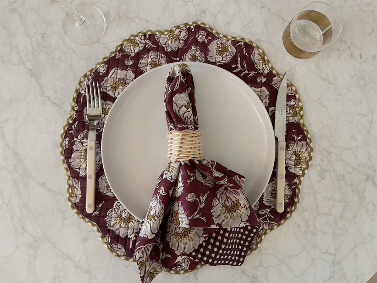 Wine floral scalloped placemat with a plate and matching printed napkin