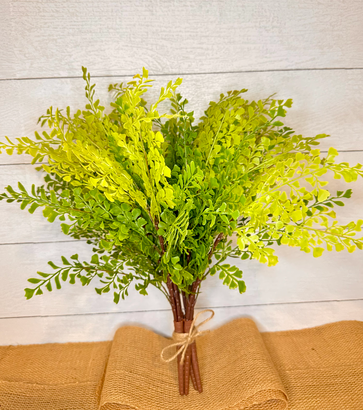 Artificial maidenhair fern bundle with bright lime-green fronds and brown stems, tied with twine