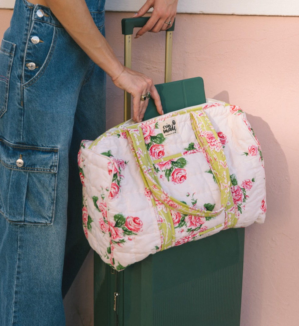 Quilted floral duffle bag carried by hand, pink rose print with yellow-green trim