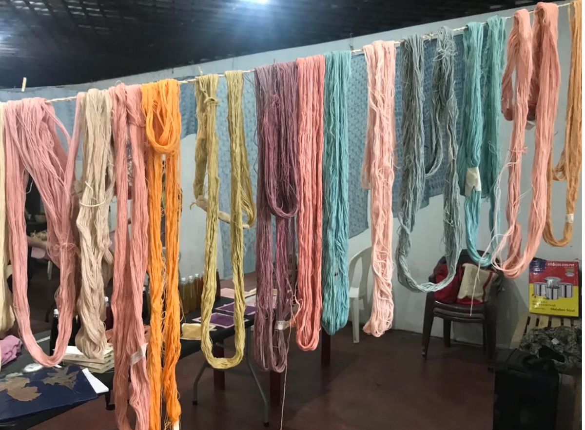 Set of shibori tassel pillows in assorted colors hanging on display with fringed tassels.