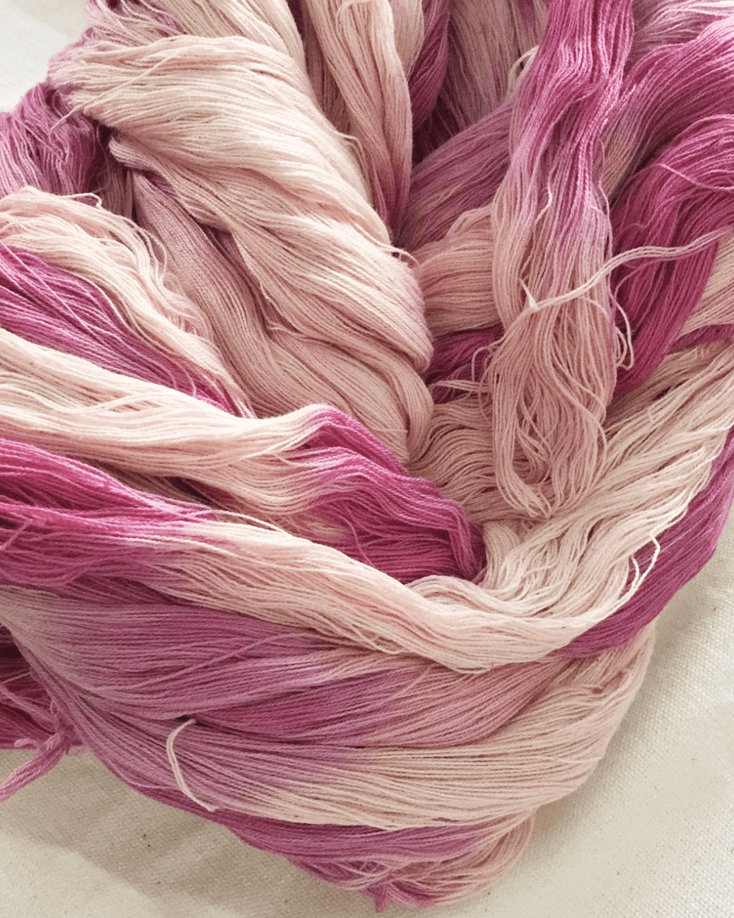 Pink natural-dyed shibori tassels detail with layered threads in light and dark shades.