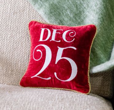 Red velvet holiday pillow with white “DEC 25” lettering and gold trim