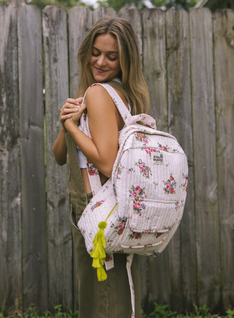Light pink quilted floral backpack with side pocket and adjustable shoulder straps