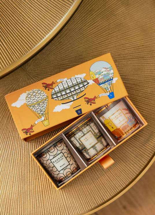 Baobab Collection trio travel candle set in open orange box, three illustrated metal tins
