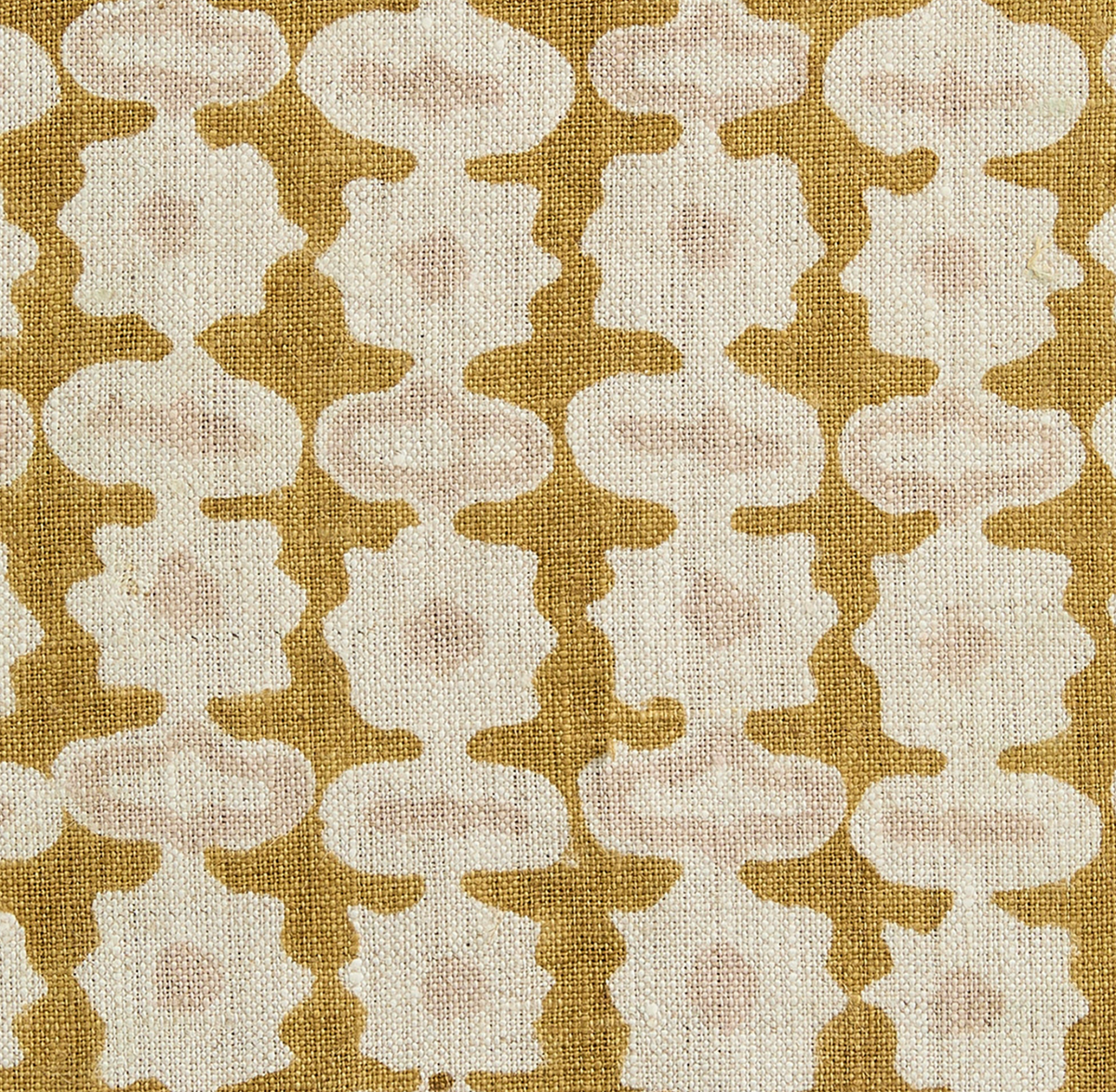 Close-up fabric of geometric pillow cover in saffron, cream, and tan