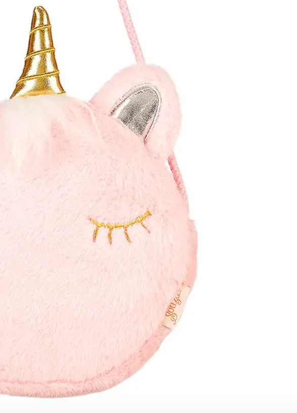 Close-up of the pink plush purse showing its gold horn, silver ear, and embroidered eye