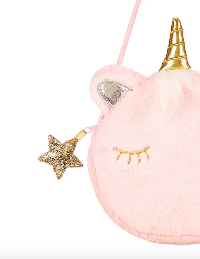 Close-up of the plush purse with a gold star charm, silver ear, and embroidered eye