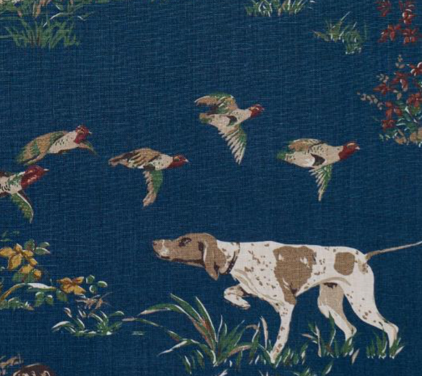 Navy pillow cover fabric detail with white-and-brown dog and flying birds.