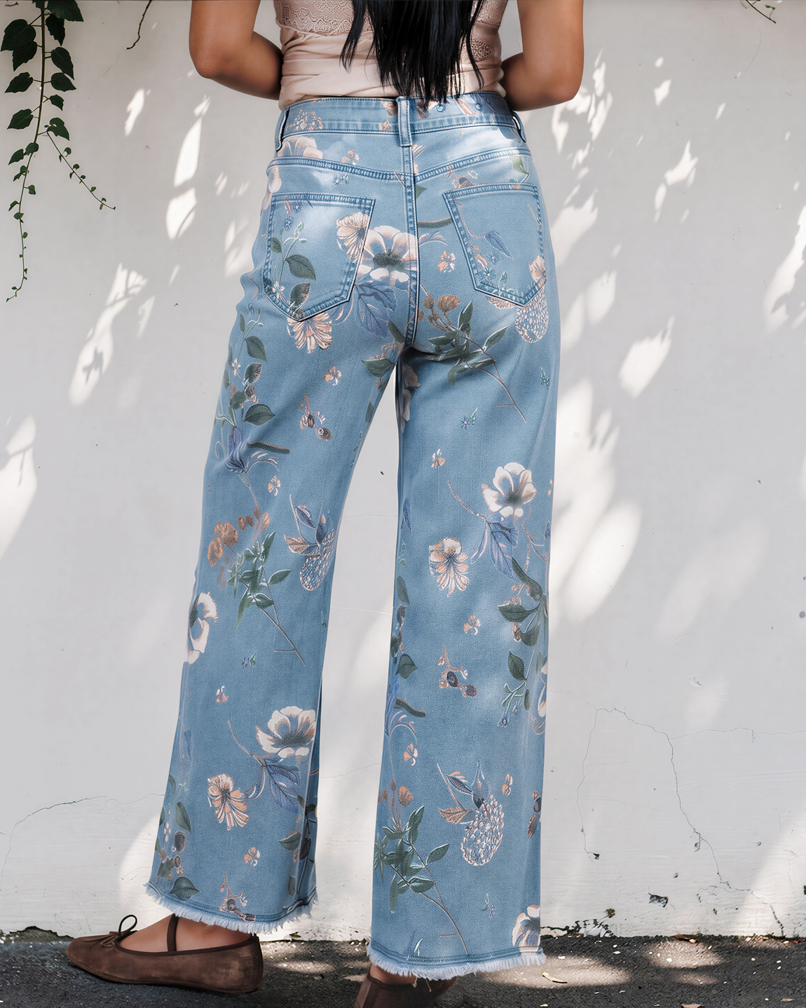 Light blue denim shift jeans with floral print, wide legs, and frayed hem