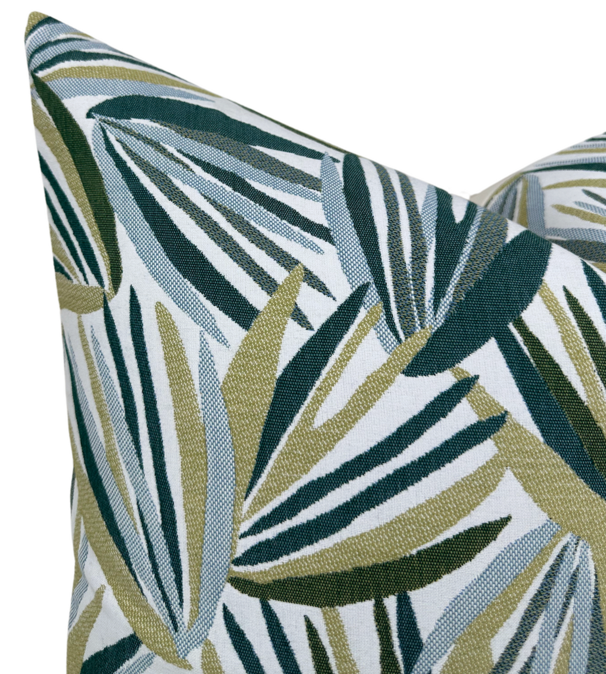 Throw pillow cover close-up: layered tropical leaf print in teal, deep green, and light cream on white.