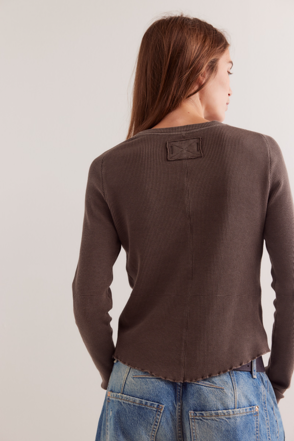 Brown long-sleeve crewneck tee back view with small rectangular patch
