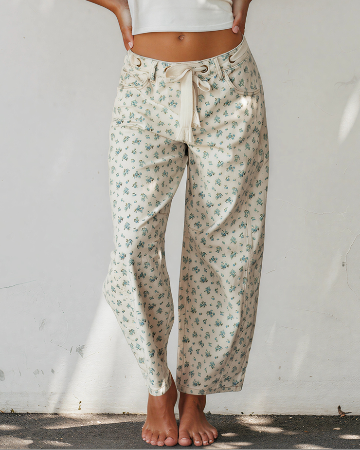 Floral knot-waist jeans with grommet tie, light base and blue-green print, barrel leg