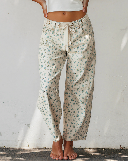 Floral knot-waist jeans with grommet tie, light base and blue-green print, barrel leg