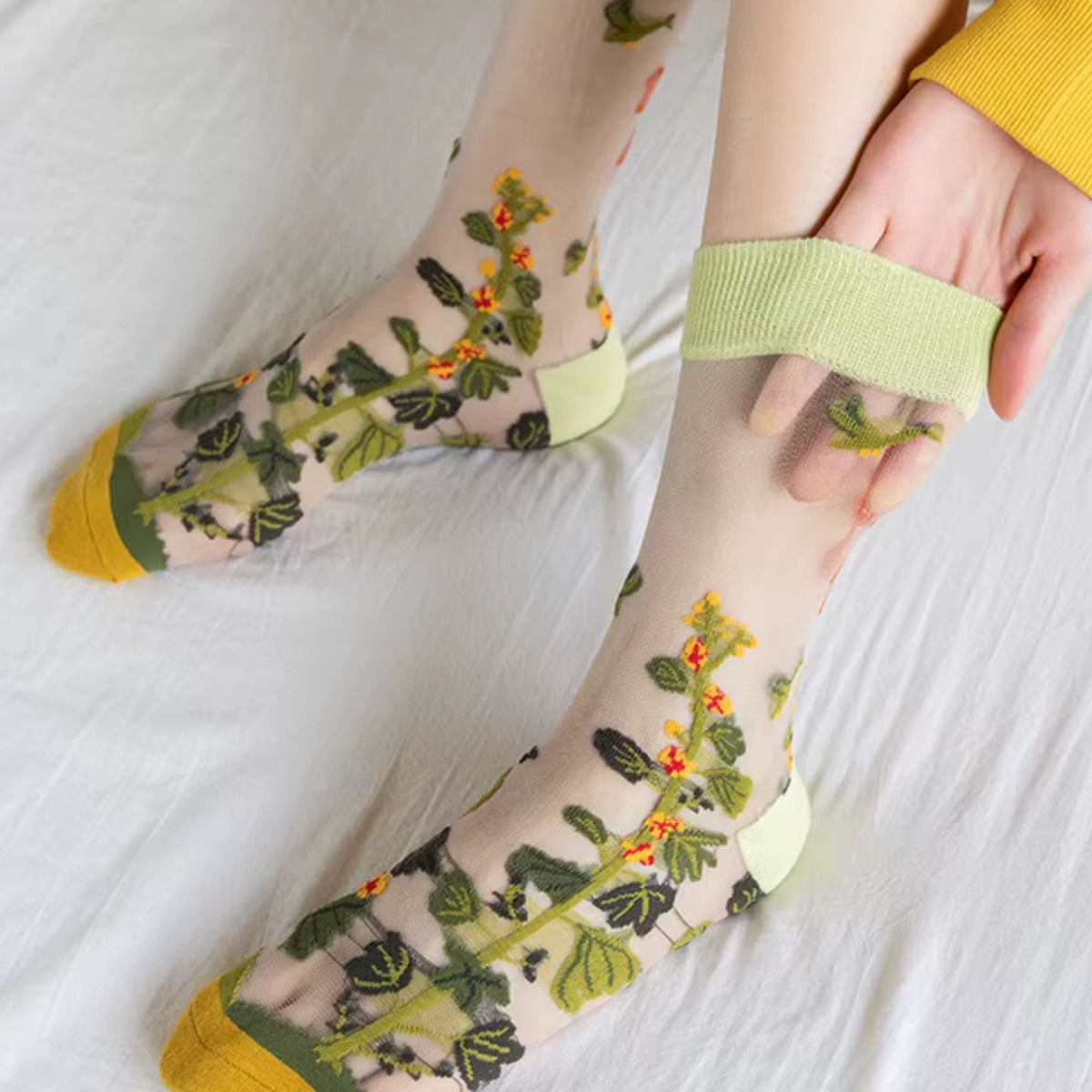 Sheer plant lover socks with leafy vines and small blossoms, yellow toe trim