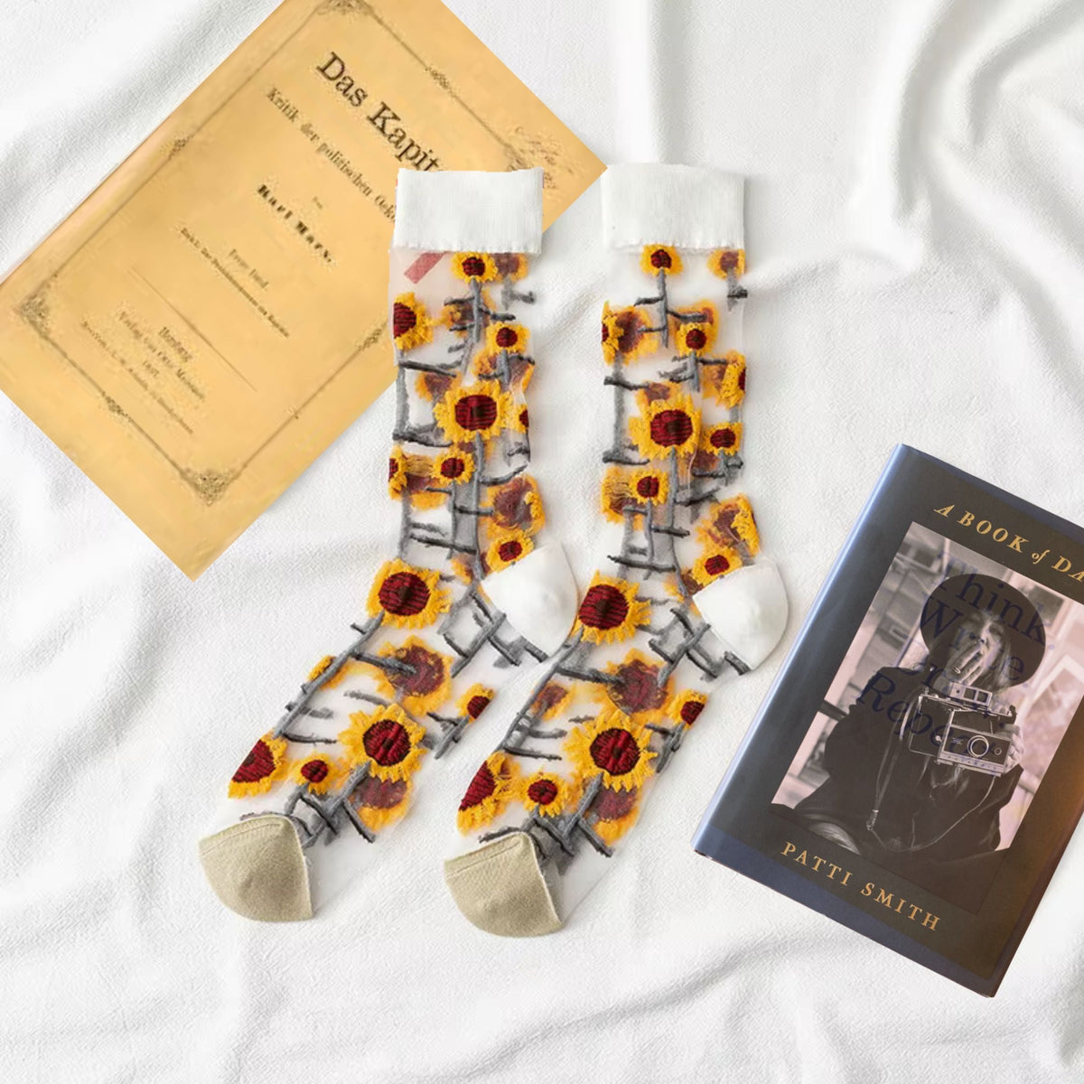Pair of sheer crew socks with yellow sunflower grid pattern and beige toe on white