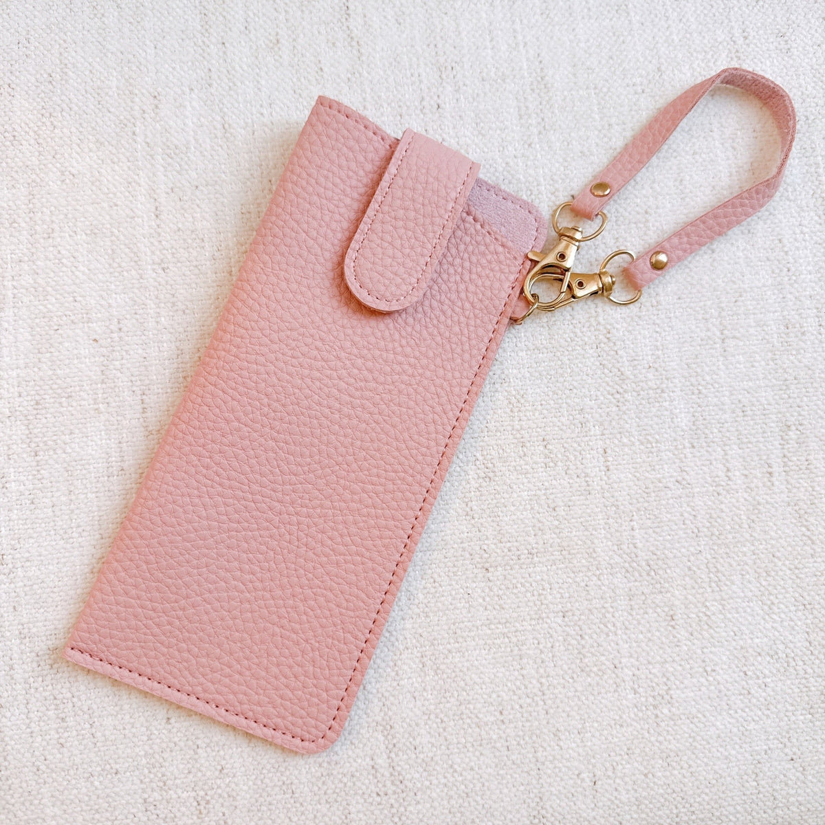 Pink bag charm glass case with wrist strap and gold-tone clasp