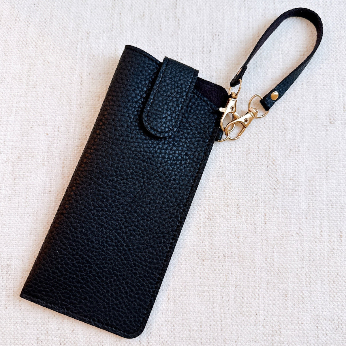 Black bag charm glass case with wrist strap and gold-tone clasp