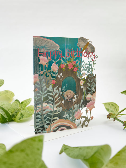 Lasercut birthday card with sleeping dormouse in teal garden, 'Happy Birthday' headline