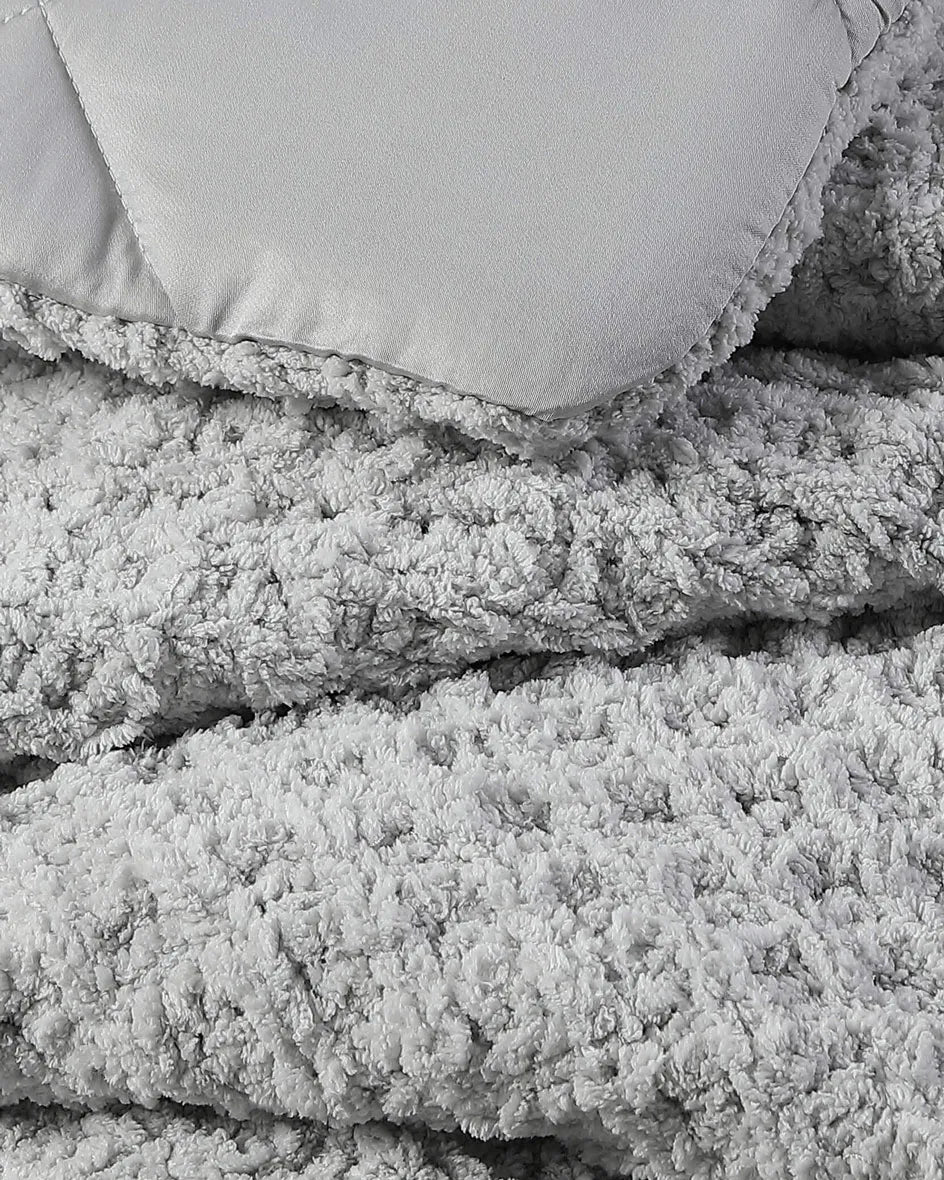 Cloud gray waffle comforter close-up with stitched edge and fluffy texture