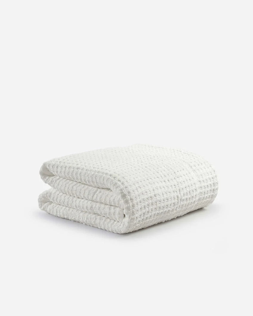 Off-white waffle comforter folded into a compact rectangle