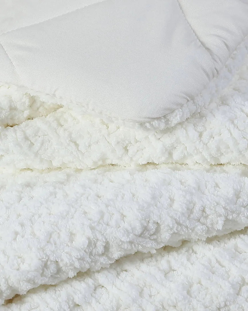 Off-white comforter with plush, textured top and stitched edge detail