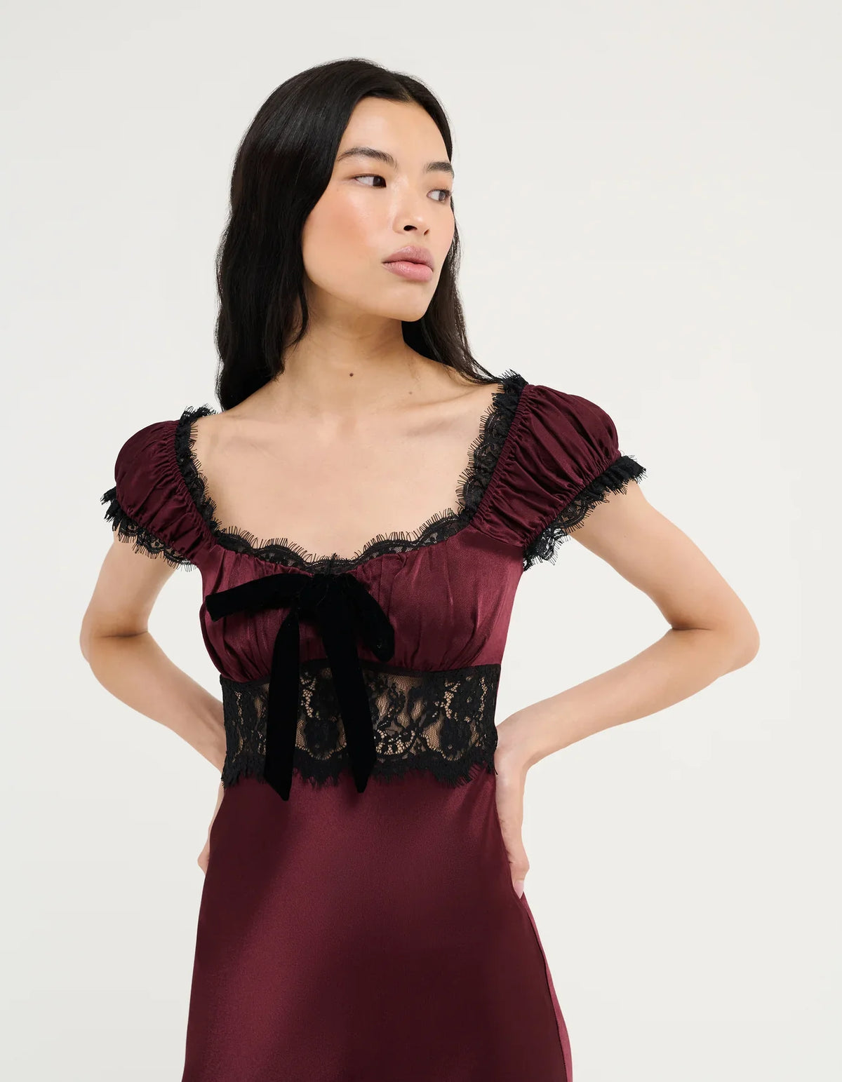 Burgundy midi dress close-up: lace bodice, ribbon bow, puff sleeves with frill
