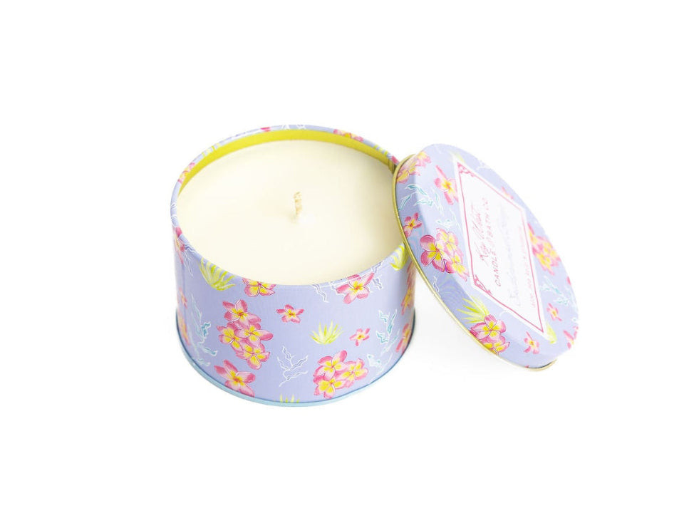 Opened round travel tin with light wax candle inside, pastel floral lid with label
