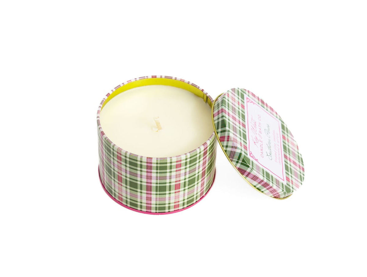 Open round plaid travel tin with lid and cream candle top inside