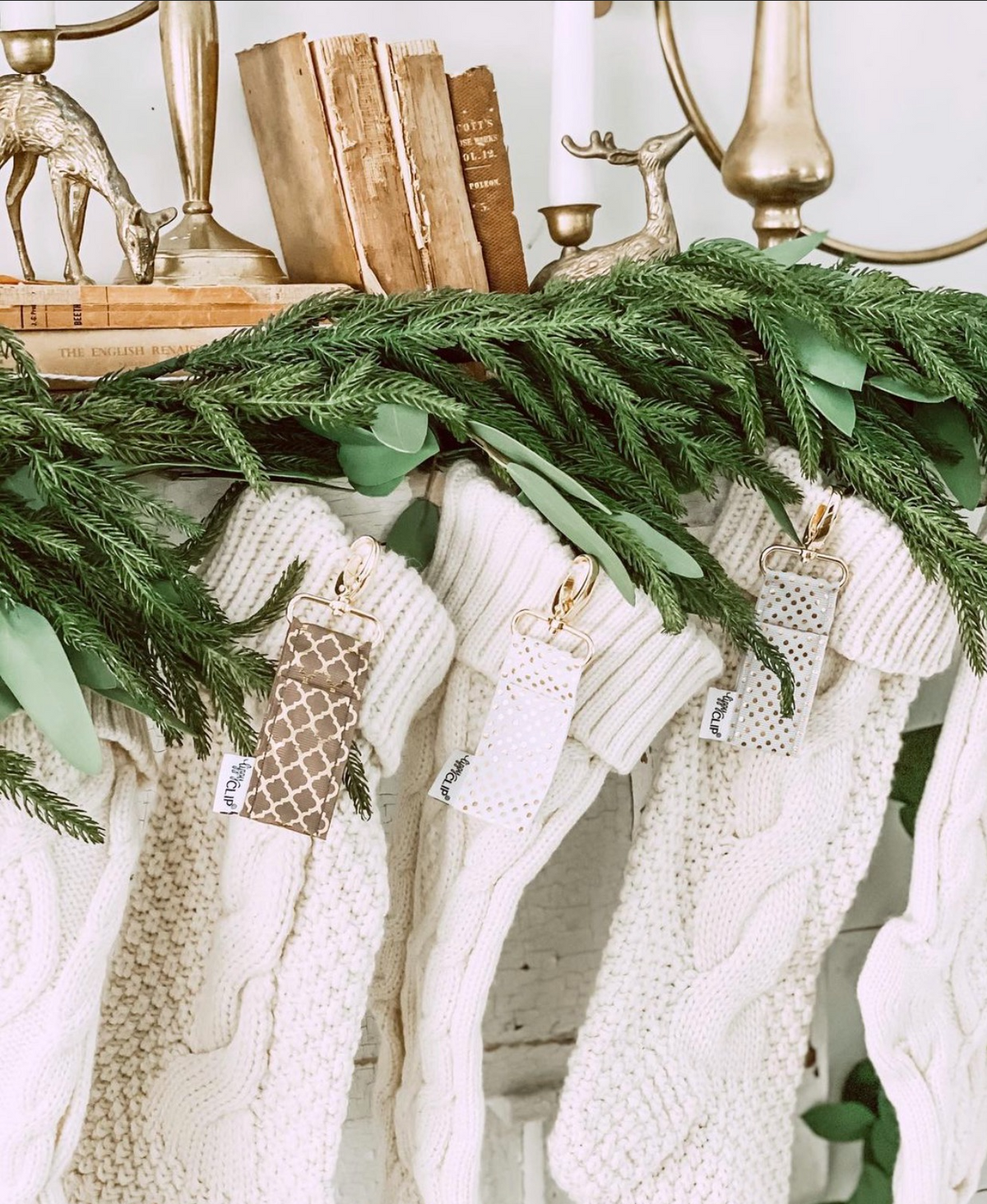White knit LippyClip® lip balm holders with gold key clips on green garland