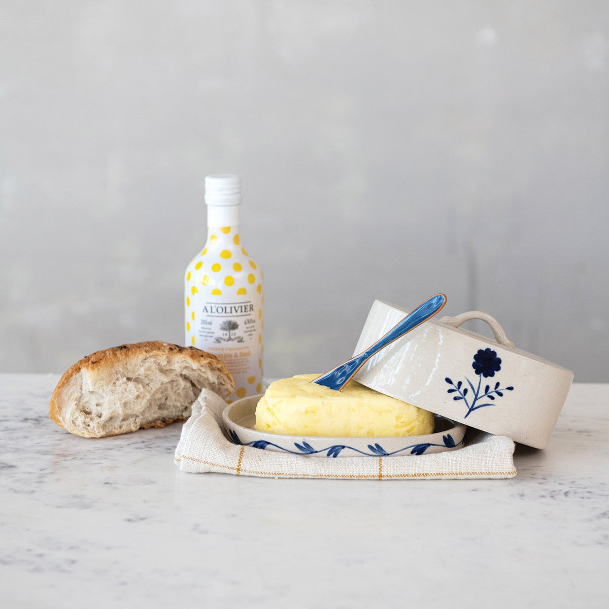 Cream stoneware butter dish with lid, blue floral motif on tray and lid handle