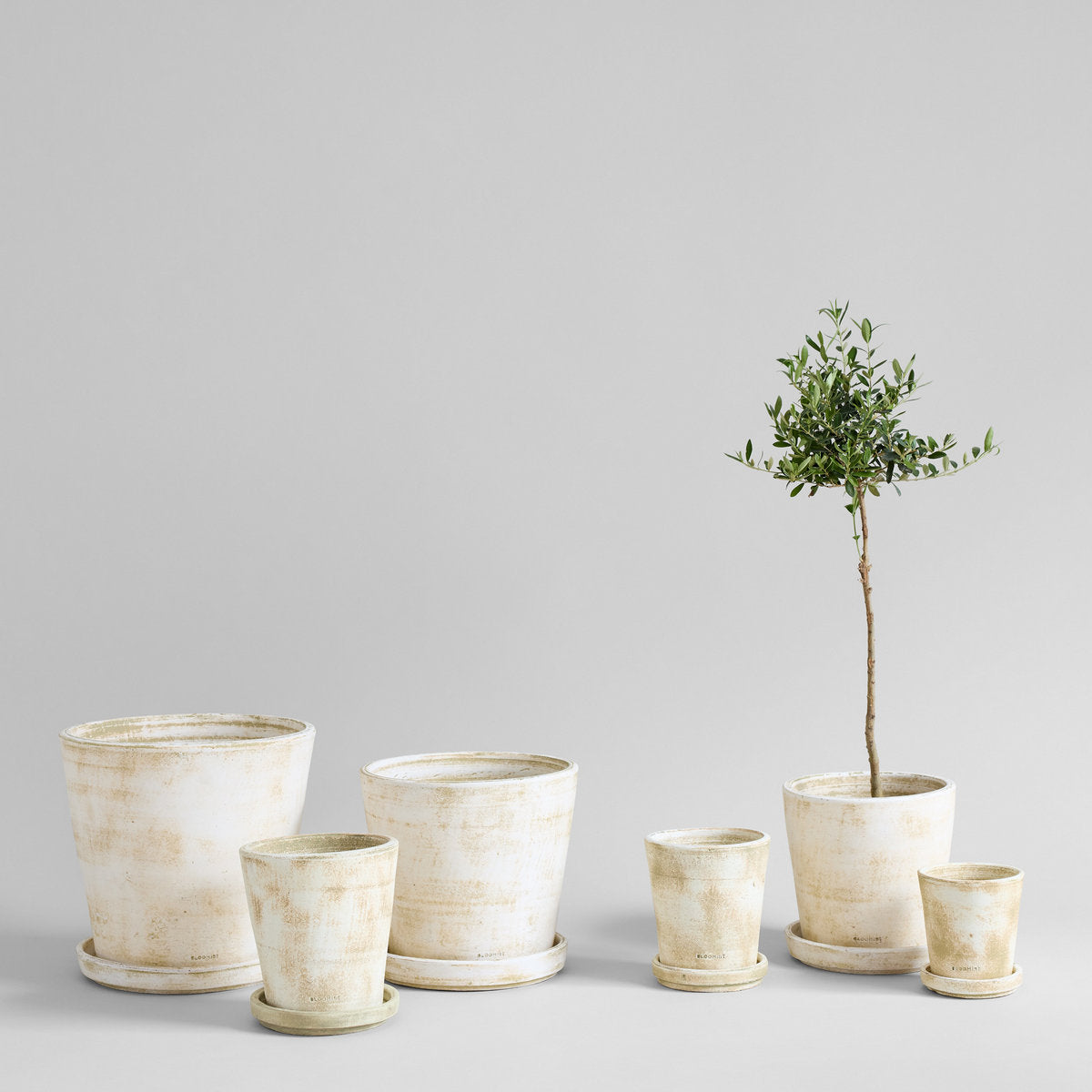Set of terra-cotta planters in white patina, nested sizes with drainage holes