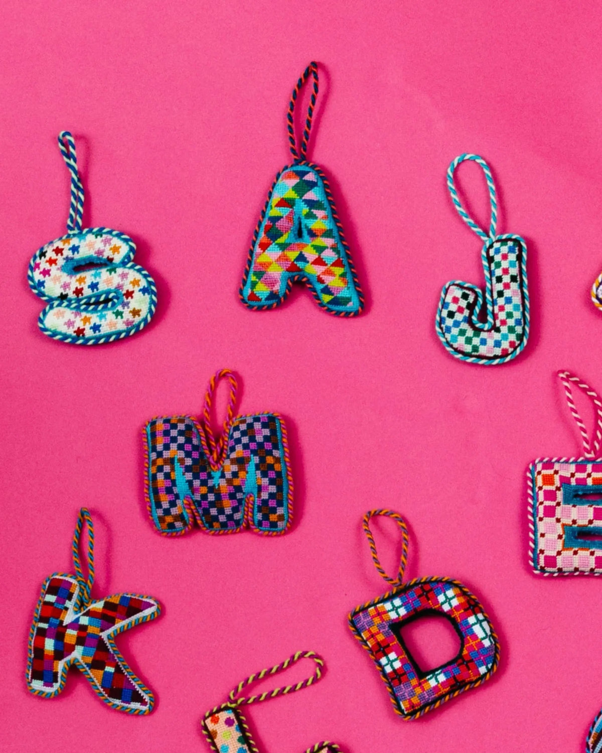 Set of multicolor needlepoint monogram ornaments, including letter A hanging loops