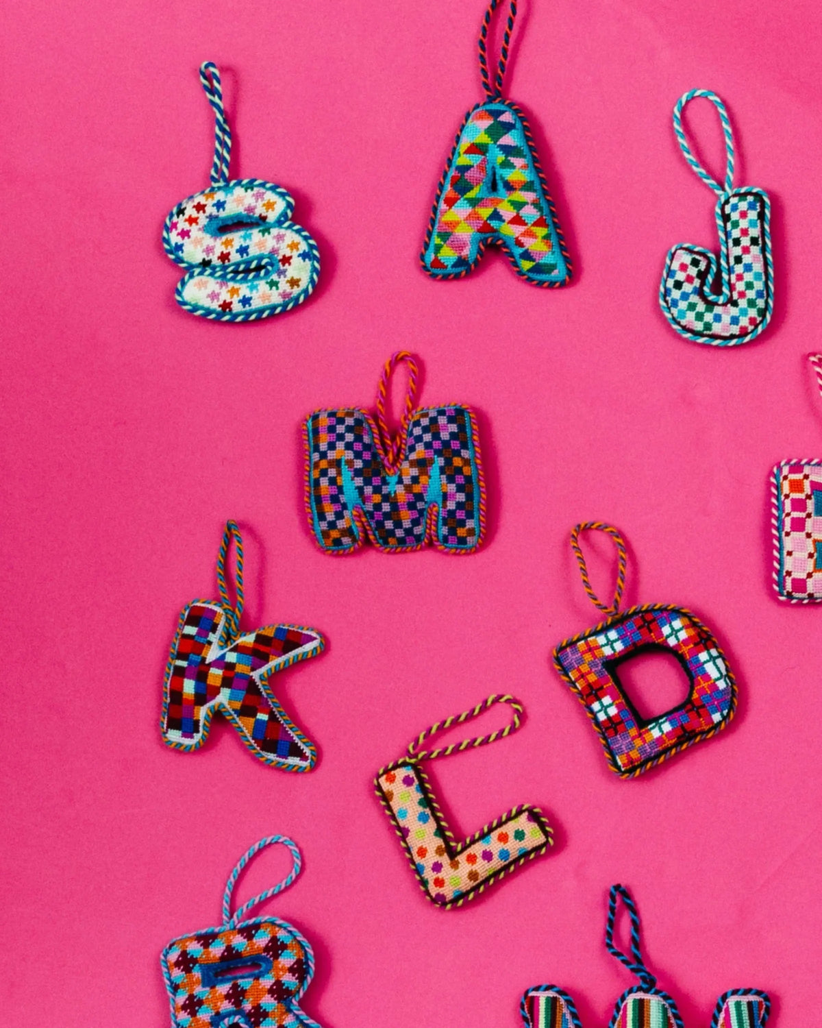 Needlepoint monogram ornament M in multicolor checkered stitch, hanging loop on top