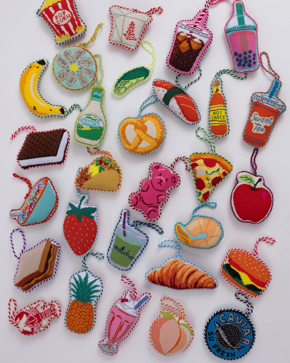 Assorted needlepoint Christmas ornaments, including a peach heart design with striped edging