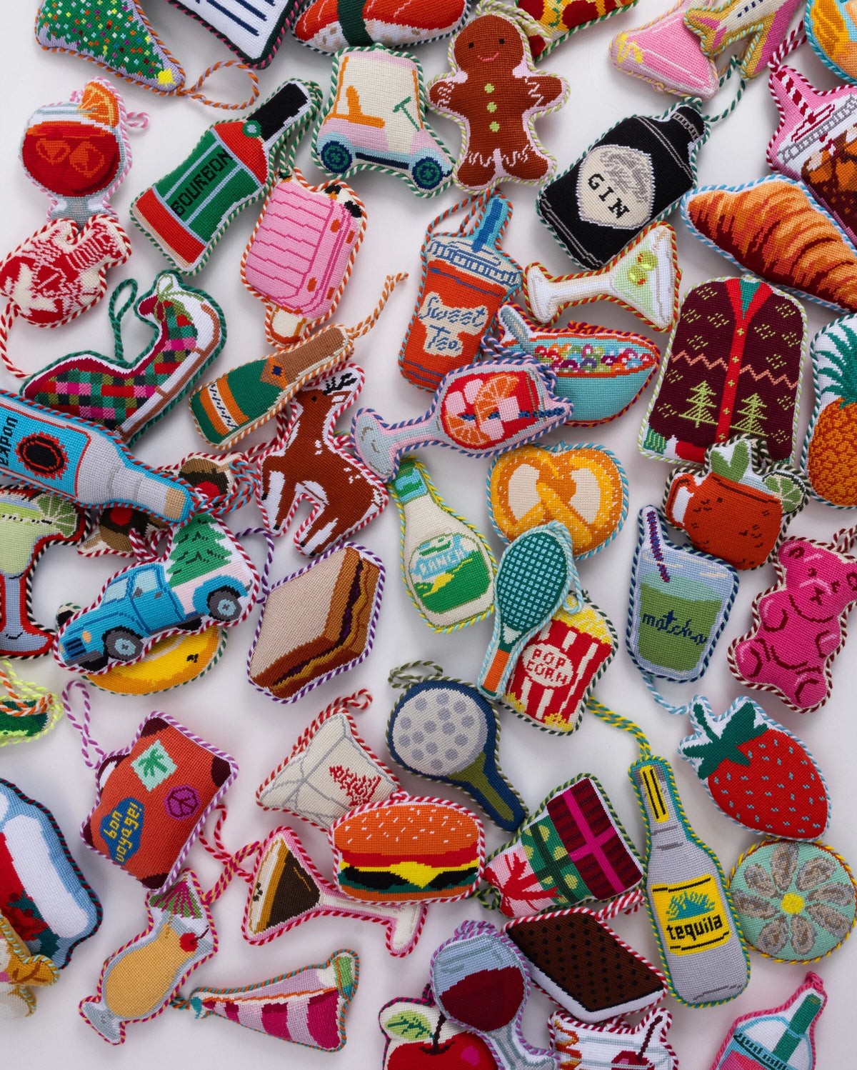 Needlepoint holiday ornaments, including teal tennis racket design with orange handle.