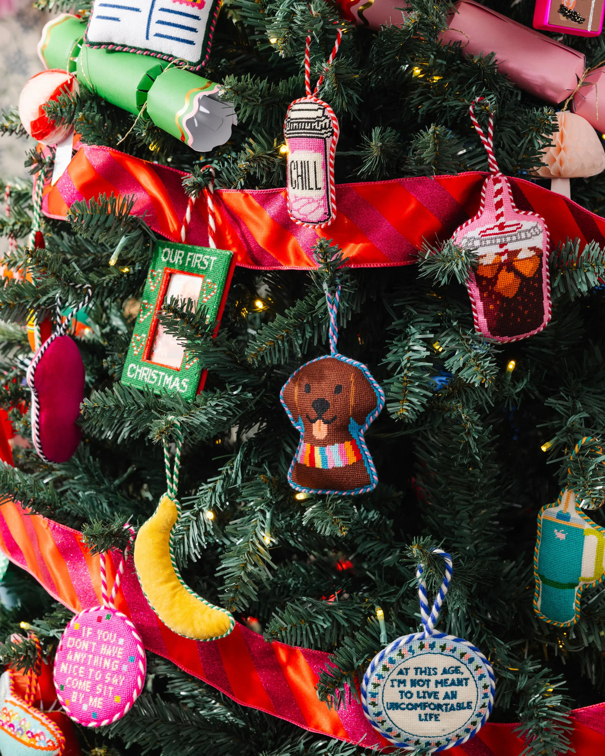 Needlepoint banana icon ornament hanging on a Christmas tree