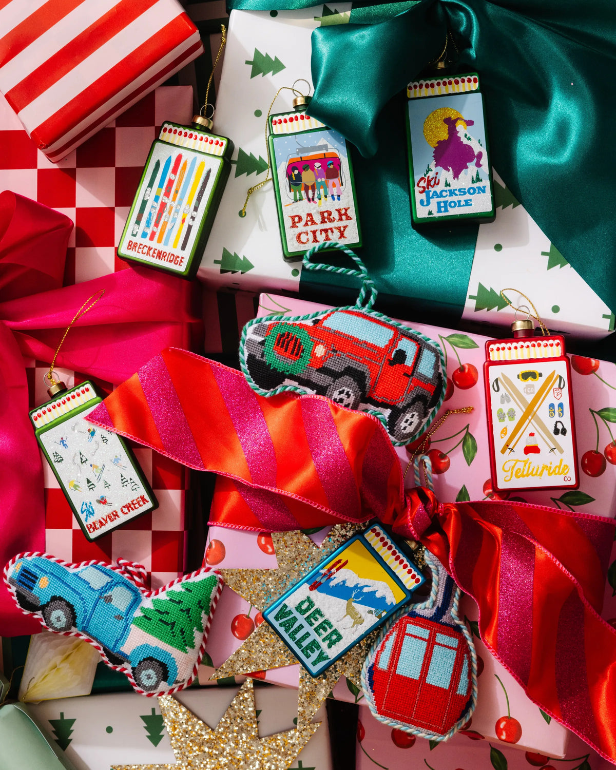 Assorted red and multicolor matchbook ornaments with hanging loops and ribbons