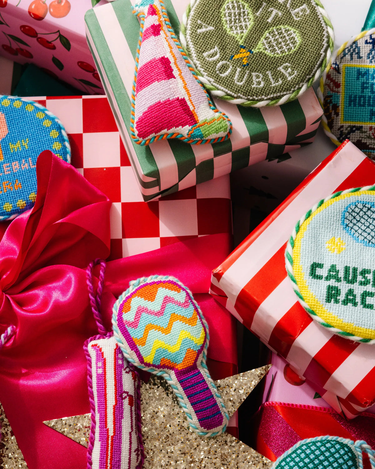 Needlepoint ornaments on gift boxes with striped sail and braided loops