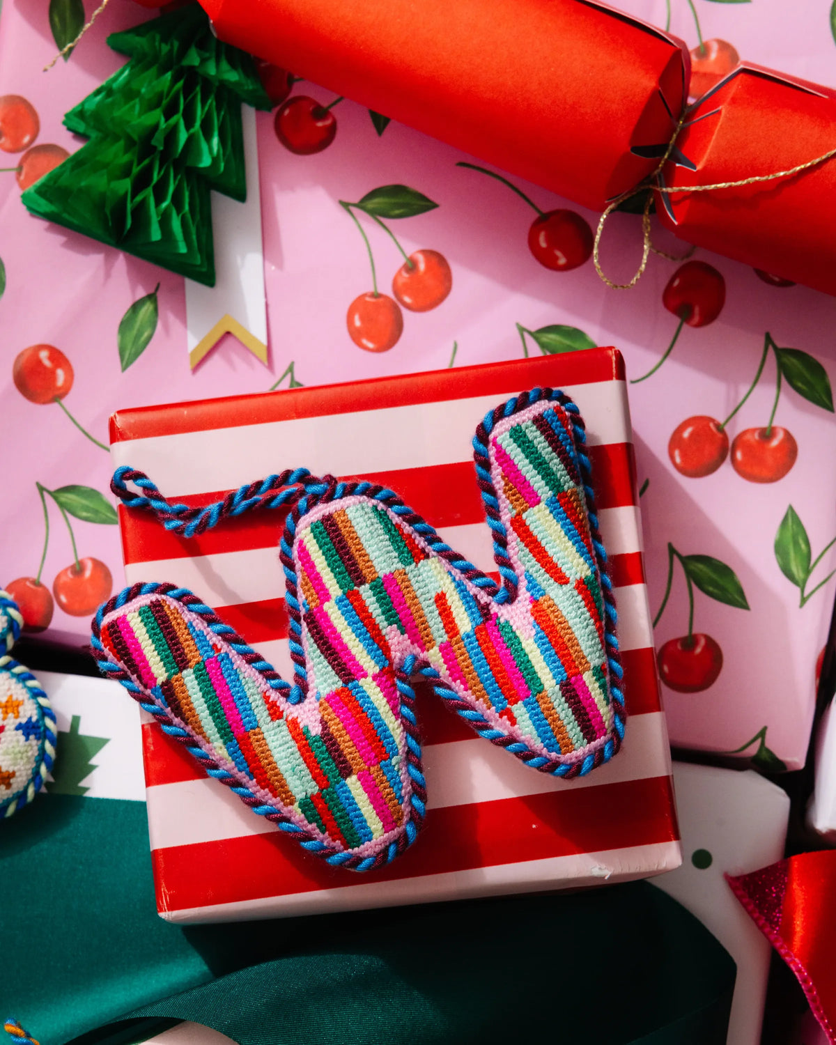 Needlepoint monogram letter W ornament with multicolor striped stitching and loop for hanging