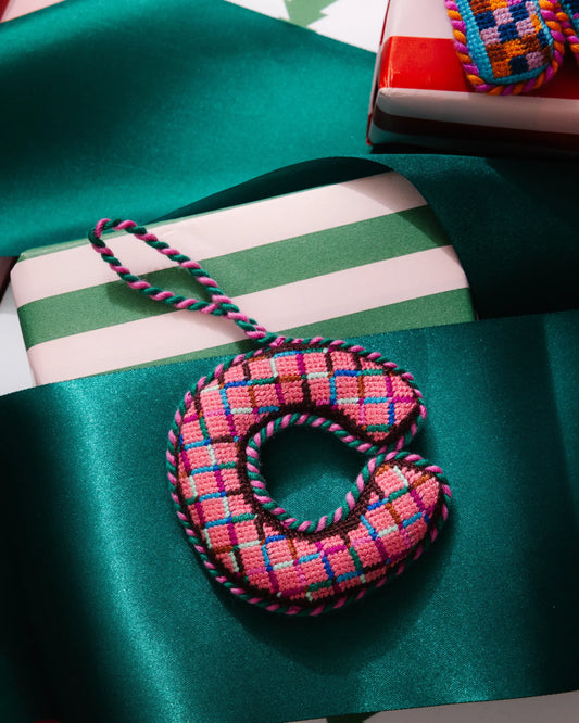 Needlepoint letter C ornament in pink, teal, and blue plaid with braided hanging cord.