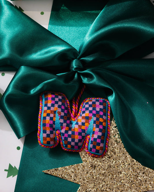 Needlepoint monogram ornament M with multicolor checkered stitching and hanging loop