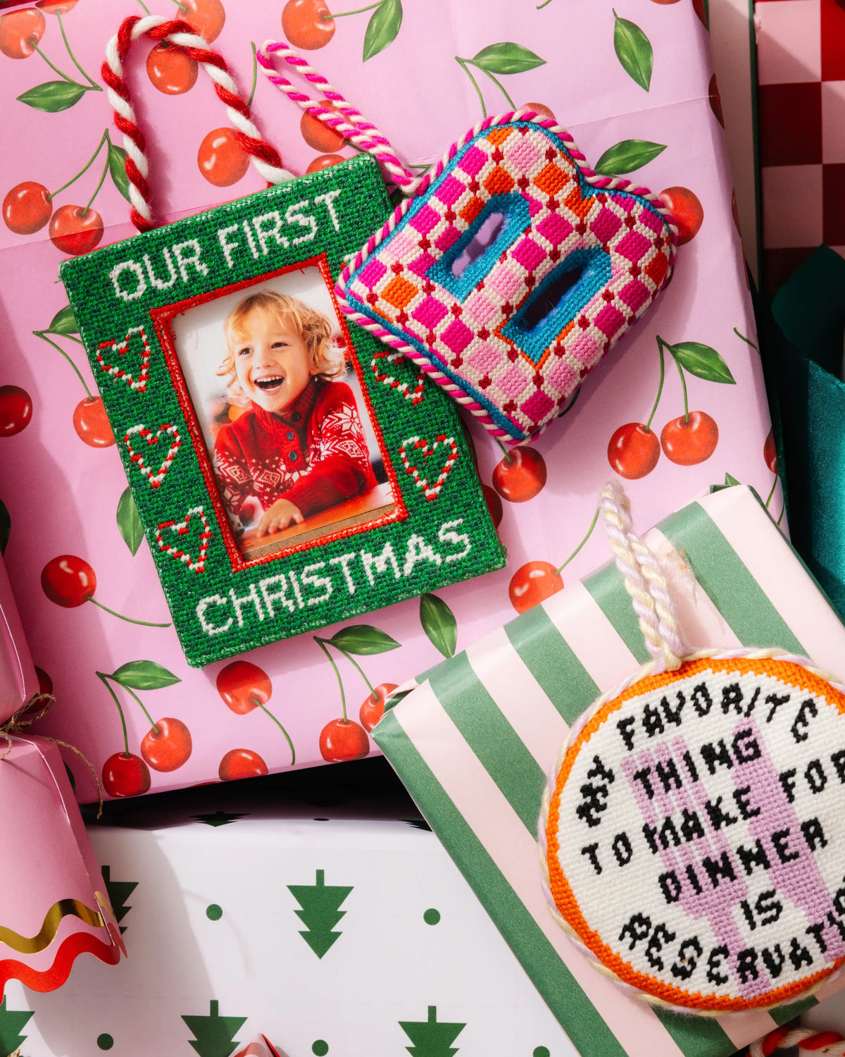 Green “Our First Christmas” photo frame ornament with braided red-and-white hanging cord