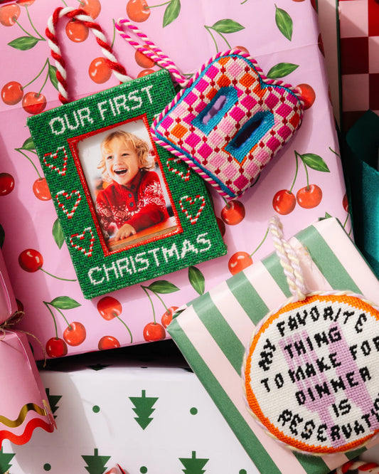 Green “Our First Christmas” photo frame ornament with braided red-and-white hanging cord