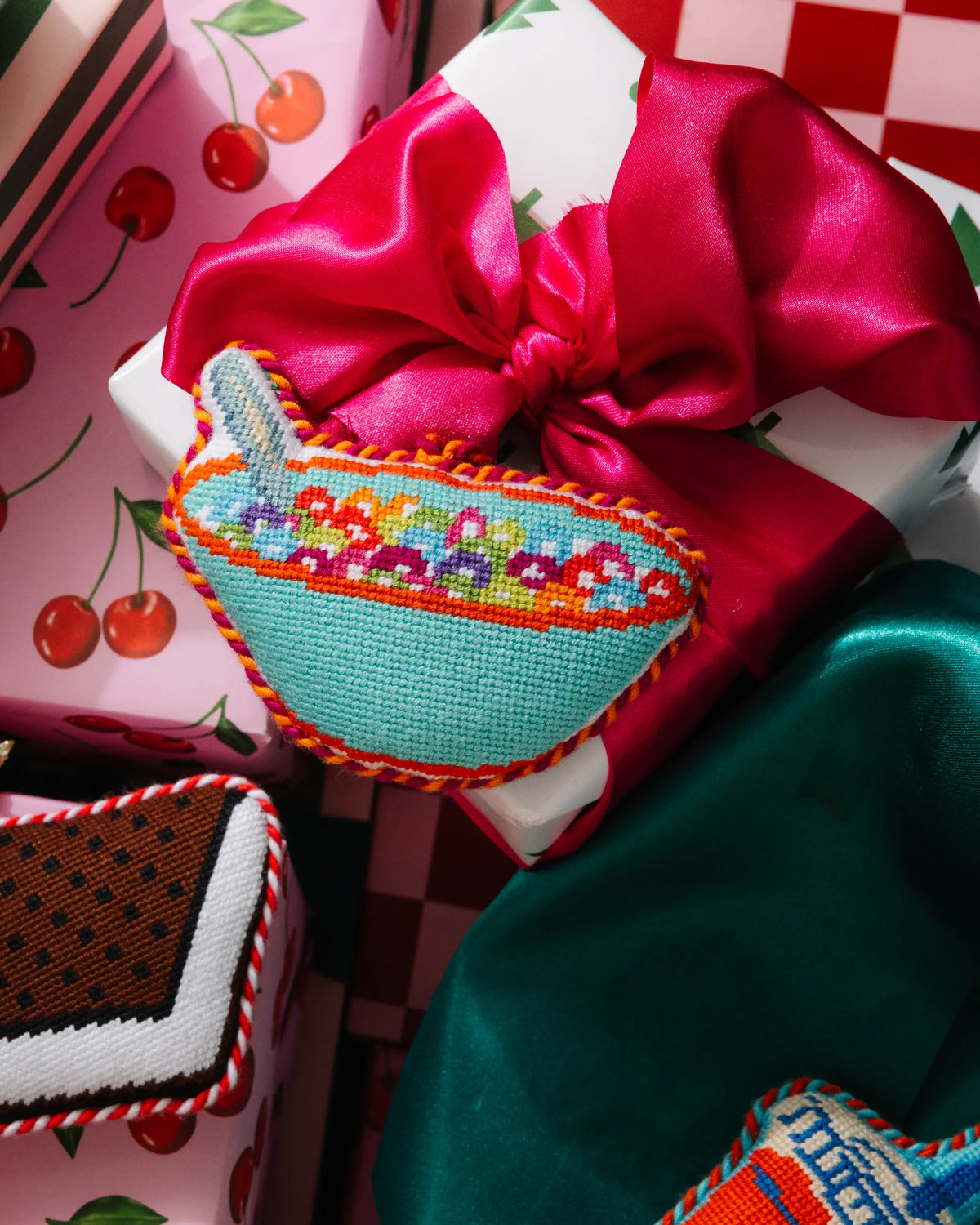 Needlepoint icon ornament of a cereal bowl, turquoise with rainbow stitched band and loop