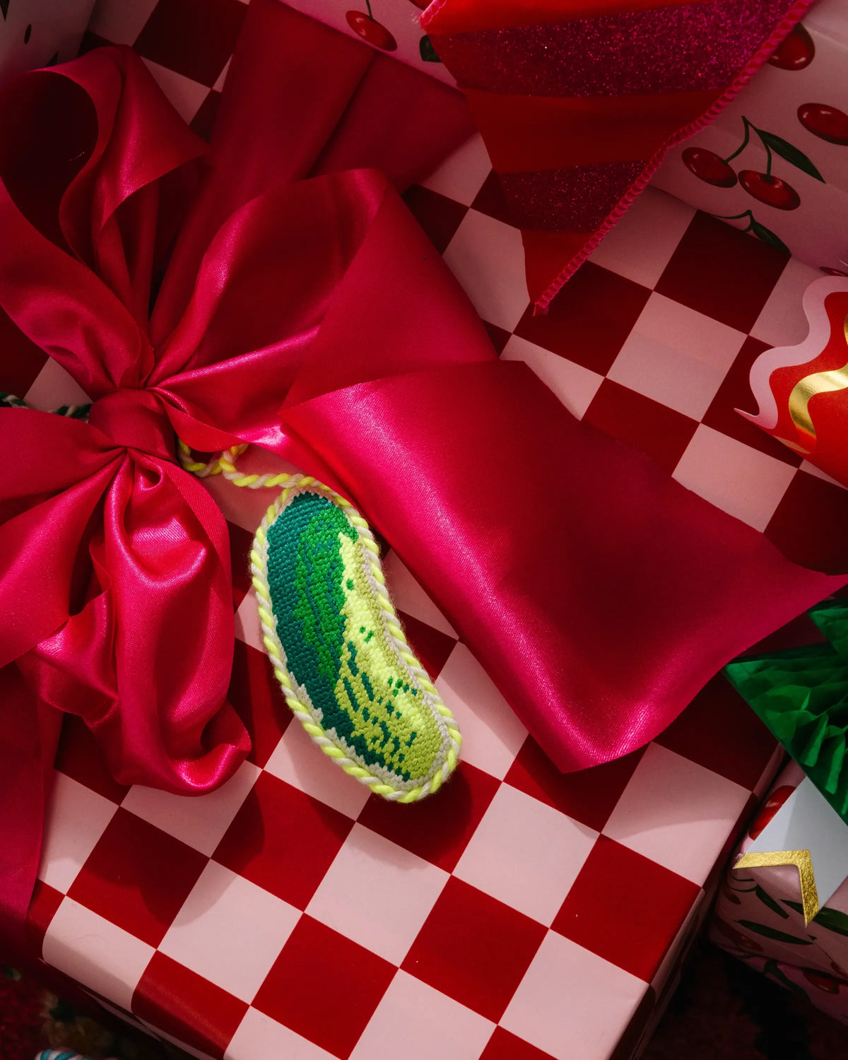 Stitched pickle ornament in green with textured needlepoint look, on white hanging cord