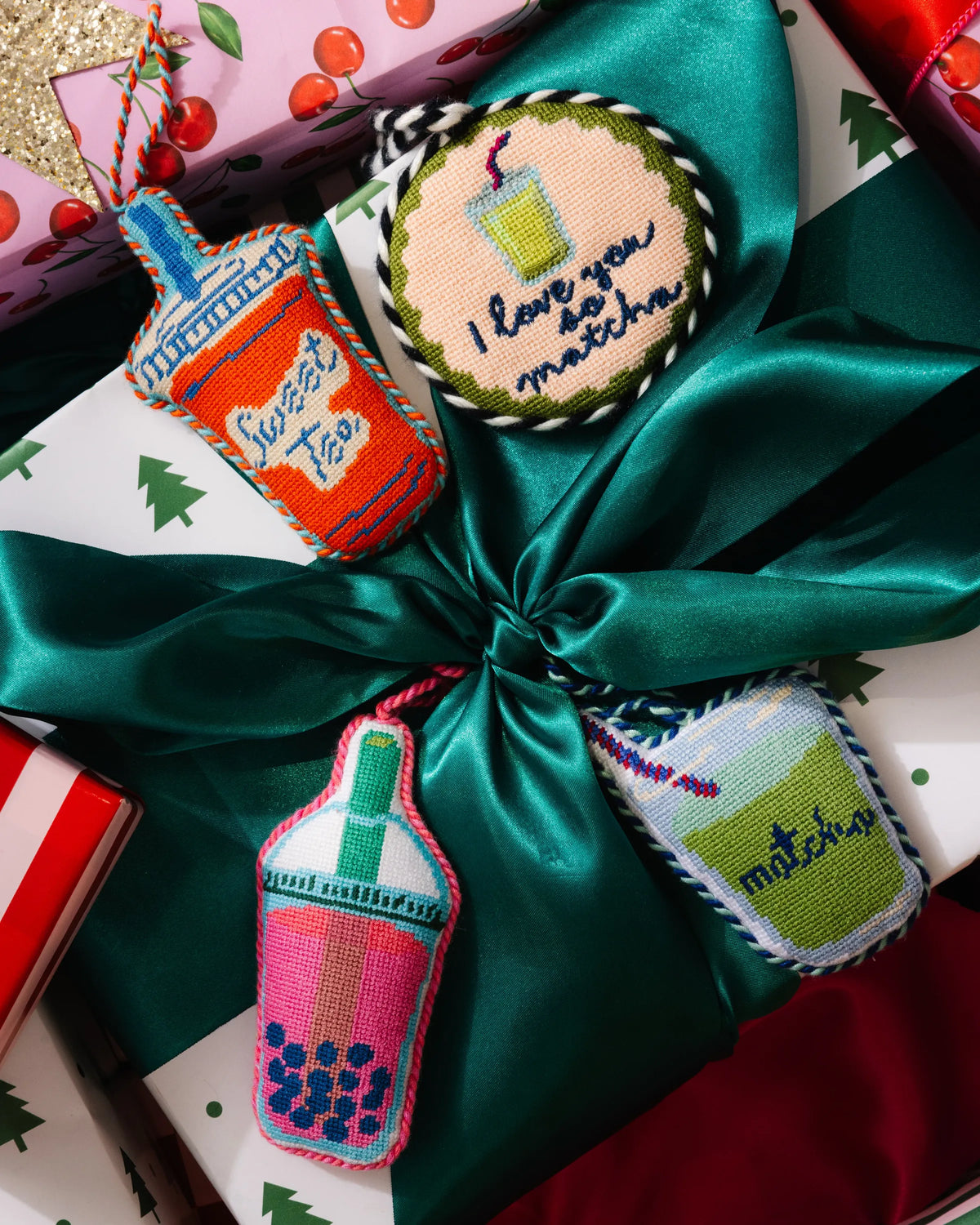 Needlepoint boba icon ornament on teal bow, stitched bottle with pink-teal panel