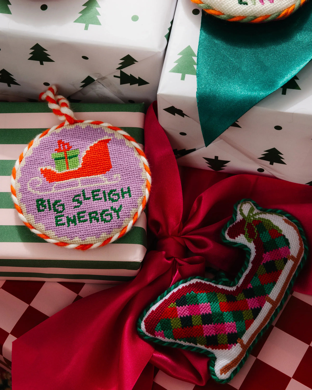 Needlepoint sleigh ornament cutout with multicolor embroidered design and hanging cord